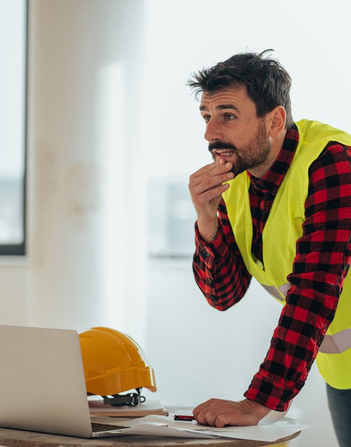 Contractor is worried while on his laptop.
